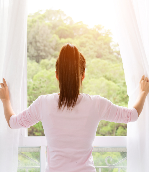 Woman looking out a windows - LULA care and maintenance